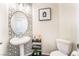 Modern powder room features a round mirror, white pedestal sink, and black and white wallpaper at 1808 Quartz Landing Ave, Las Vegas, NV 89183