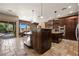Open concept kitchen with stainless appliances, dark wood cabinets, stone floors and counters at 1981 Trophy Elk Ave, Logandale, NV 89021