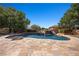 Beautiful pool with a rock waterfall and slide, surrounded by a stone patio and mature trees at 1981 Trophy Elk Ave, Logandale, NV 89021