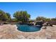 Lush backyard features a large swimming pool with rock accents and a slide at 1981 Trophy Elk Ave, Logandale, NV 89021