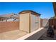 Storage shed in backyard with beige siding and wooden trim at 1981 Trophy Elk Ave, Logandale, NV 89021