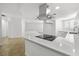 Bright kitchen featuring an island with cooktop, stainless steel vent hood, and tile flooring at 2080 Karen Ave # 60, Las Vegas, NV 89169