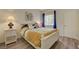 Bedroom featuring a large bed with yellow bedding, bright window, and side table at 2615 W Gary Ave # 2013, Las Vegas, NV 89123