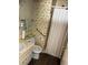 Modest bathroom featuring wood-look floors, accessible grab bars, and a shower with a white curtain at 2724 Natalie Ave, Las Vegas, NV 89121