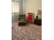A neutral bedroom featuring multiple sitting chairs and a vintage wooden side table at 2724 Natalie Ave, Las Vegas, NV 89121