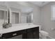 Modern bathroom with dark cabinetry, a white countertop and sink, and a large framed mirror at 2827 Turnstone Ridge St, Henderson, NV 89044