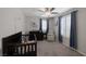 Bright Bedroom featuring neutral walls, gray carpeting, ceiling fan and a dark wood crib and changing table combo at 2827 Turnstone Ridge St, Henderson, NV 89044