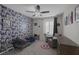 Bedroom featuring playful wallpaper, ceiling fan, and shuttered window at 2827 Turnstone Ridge St, Henderson, NV 89044