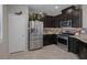 Modern kitchen with stainless steel appliances, dark wood cabinets, and granite countertops at 2827 Turnstone Ridge St, Henderson, NV 89044