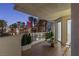 Balcony seating with a view of lush palms, a pool, and city buildings at twilight at 2857 Paradise Rd # 305, Las Vegas, NV 89109
