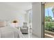 Light-filled bedroom features a comfortable bed, plush armchair, and balcony access with city views at 2857 Paradise Rd # 305, Las Vegas, NV 89109