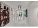 Hallway featuring white tile floors, modern lighting, and elegant artwork, leading to a comfortable living space at 2857 Paradise Rd # 305, Las Vegas, NV 89109
