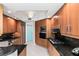 Contemporary kitchen with wood cabinets, granite countertops, and modern stainless appliances at 2857 Paradise Rd # 305, Las Vegas, NV 89109