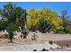 Home featuring a stone wall, several trees, and bushes at 3104 Archwood Way, Las Vegas, NV 89134