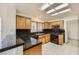 Functional kitchen with black appliances, wood cabinets, and a skylight for natural lighting at 3104 Archwood Way, Las Vegas, NV 89134
