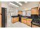 Efficient kitchen featuring wood cabinets, black countertops, and modern appliances at 3104 Archwood Way, Las Vegas, NV 89134