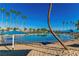 Community pool with sandy beach entry and palm trees around the edge at 3151 Soaring Gulls Dr # 2136, Las Vegas, NV 89128
