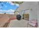 Cozy back patio with chairs, a grill, and a view of neighboring homes under a sunny sky at 4820 Integrity St, North Las Vegas, NV 89031