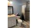Functional bathroom featuring a white vanity, toilet, and a shower with neutral tile surround at 4834 E Van Buren Ave, Las Vegas, NV 89110