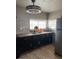Updated kitchen features dark cabinetry, tile backsplash, and a stainless steel refrigerator, maximizing the space at 4834 E Van Buren Ave, Las Vegas, NV 89110