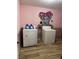 Functional laundry room with washer, dryer, wood-look flooring, and fun wall art, making laundry a little more enjoyable at 4834 E Van Buren Ave, Las Vegas, NV 89110