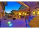 Spacious backyard has a tiki-themed bar, outdoor kitchen, fire pit, covered patio, and more at 603 Fiddlehead Ave, Las Vegas, NV 89183