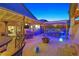 Backyard oasis featuring a tiki bar, outdoor kitchen, dining area, a fire pit, and desert landscaping at 603 Fiddlehead Ave, Las Vegas, NV 89183