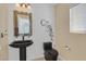 A modern half bathroom features a sleek black sink and toilet, decorative mirror, and a stylish design at 603 Fiddlehead Ave, Las Vegas, NV 89183