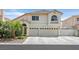 Charming two-story home with a tile roof, arched doorway, and a well-manicured front yard at 603 Fiddlehead Ave, Las Vegas, NV 89183