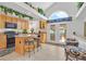 Well-lit kitchen with wooden cabinets, granite countertops, and a breakfast bar with seating at 603 Fiddlehead Ave, Las Vegas, NV 89183
