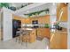 A bright kitchen features tile floors, light wood cabinets, granite countertops, and a stylish island with stools at 603 Fiddlehead Ave, Las Vegas, NV 89183
