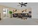 Spacious carpeted living room featuring a sectional sofa, ceiling fan, modern decor, and bright natural light at 603 Fiddlehead Ave, Las Vegas, NV 89183