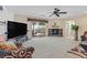 Cozy living room with fireplace, ceiling fan, neutral carpet and slider to covered patio and backyard at 603 Fiddlehead Ave, Las Vegas, NV 89183