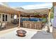 Outdoor bar with a tiki theme, complete with a thatched roof, seating, and a decorative backdrop at 603 Fiddlehead Ave, Las Vegas, NV 89183