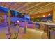 Luxurious outdoor kitchen boasts stone counters, modern appliances, and a cozy tiki-style dining area at 603 Fiddlehead Ave, Las Vegas, NV 89183