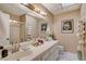 Bright bathroom with dual sinks, a large mirror, white countertops, shower and toilet at 611 Spyglass Ln, Las Vegas, NV 89107