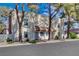 Charming townhome featuring a stucco facade, red tile accents, and mature landscaping at 611 Spyglass Ln, Las Vegas, NV 89107