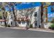 Charming townhome featuring a stucco facade, red tile accents, and mature landscaping at 611 Spyglass Ln, Las Vegas, NV 89107