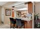 Updated kitchen area featuring a breakfast bar, tile countertops, and a bright, open design at 611 Spyglass Ln, Las Vegas, NV 89107