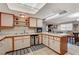 Functional kitchen with white cabinetry, tiled countertops, stainless steel features, and an eat-in bar at 611 Spyglass Ln, Las Vegas, NV 89107