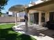 Covered back patio features green lawn and leads into the home through sliding glass doors at 6508 Alpine Forest Ct, Las Vegas, NV 89149