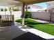 Inviting backyard featuring a covered patio, green lawn area, and a trampoline, perfect for outdoor enjoyment at 6508 Alpine Forest Ct, Las Vegas, NV 89149