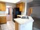 Charming kitchen with tile floors, stainless steel fridge, light wood cabinets and bright white countertops at 6508 Alpine Forest Ct, Las Vegas, NV 89149