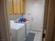 This laundry room features a washer, dryer, tile floors and light wood cabinets at 6508 Alpine Forest Ct, Las Vegas, NV 89149