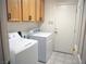The laundry room features a washer, dryer, tile floors, and light wood cabinets at 6508 Alpine Forest Ct, Las Vegas, NV 89149