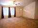 Bright living room featuring neutral carpet, a ceiling fan, and access to front door at 6508 Alpine Forest Ct, Las Vegas, NV 89149