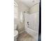 Cozy bathroom featuring a combined tub and shower with white tile surround and wood-look flooring at 7364 Marbury St, Las Vegas, NV 89166
