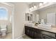 Bright bathroom with dual square sinks, dark cabinets, and a window for natural light at 7364 Marbury St, Las Vegas, NV 89166