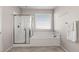 This luxurious bathroom offers a relaxing tub, a glass-enclosed shower, and ample natural light at 7364 Marbury St, Las Vegas, NV 89166