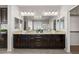 Bathroom with double sinks, granite countertops, and dark wood cabinets and a walk-in closet at 7364 Marbury St, Las Vegas, NV 89166